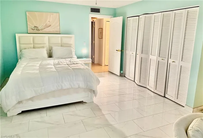 Bedroom featuring light marble finish flooring and a closet
