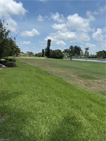 View of the back of the property, featuring a view of the lake and golf course