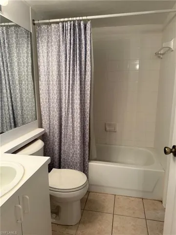 Bathroom featuring light tile patterned floors, shower / bath combo, and vanity