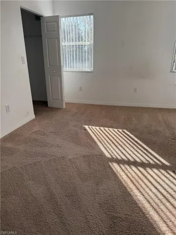 Carpeted empty room featuring baseboards