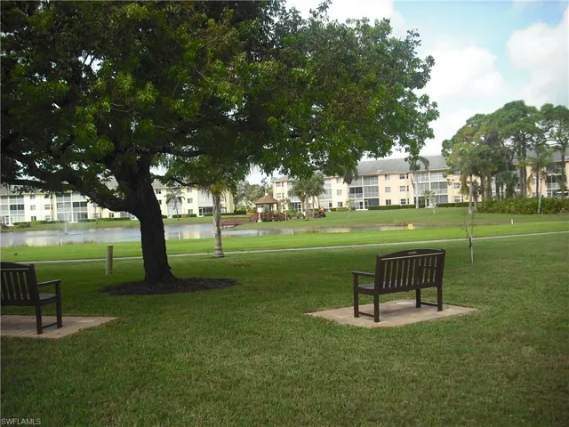 View of property's community featuring a lawn and a water view