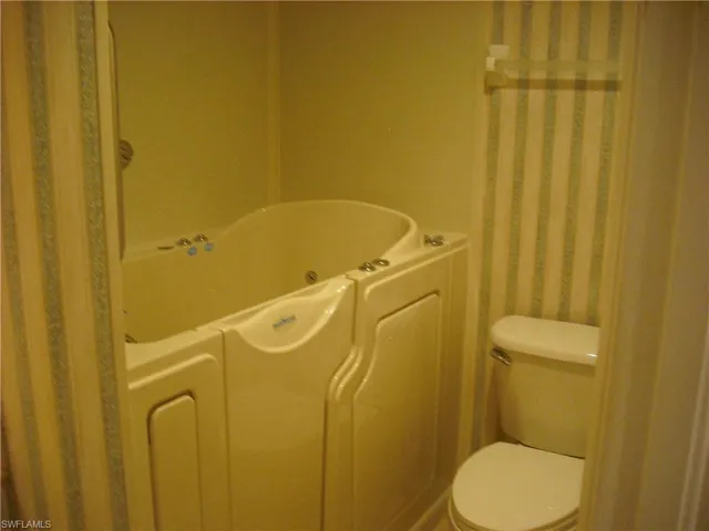 Bathroom with toilet and a tub to relax in