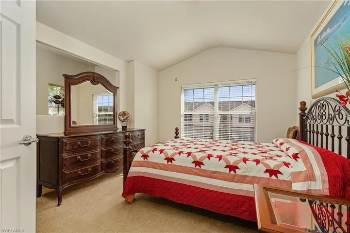 Carpeted bedroom featuring lofted ceiling