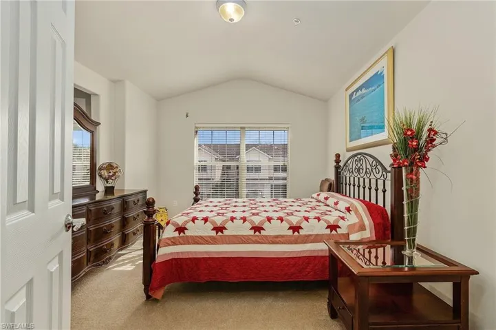Bedroom featuring carpet and vaulted ceiling