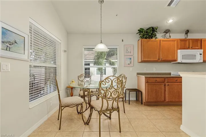 Tiled dining space featuring a wealth of natural light and lofted ceiling
