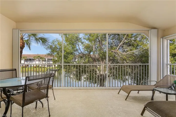 Sunroom featuring a water view and lofted ceiling