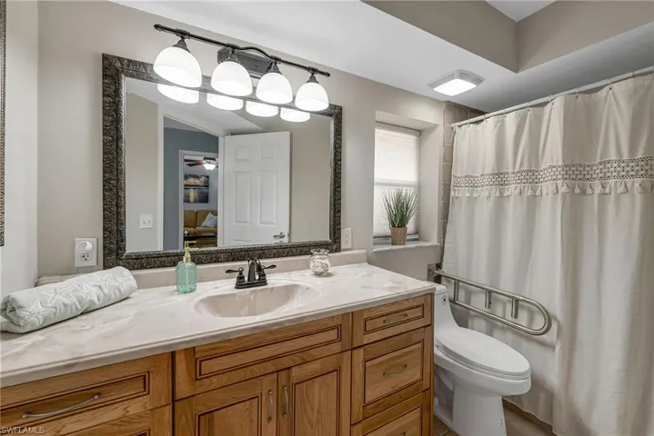 Bathroom with vanity, ceiling fan, and toilet