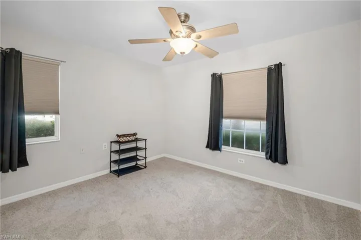 Carpeted  room featuring ceiling fan