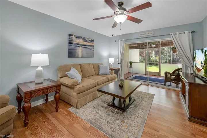 Living room with ceiling fan and light hardwood / wood-style floors