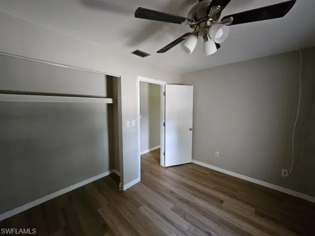 Unfurnished bedroom featuring a closet, hardwood / wood-style flooring, and ceiling fan