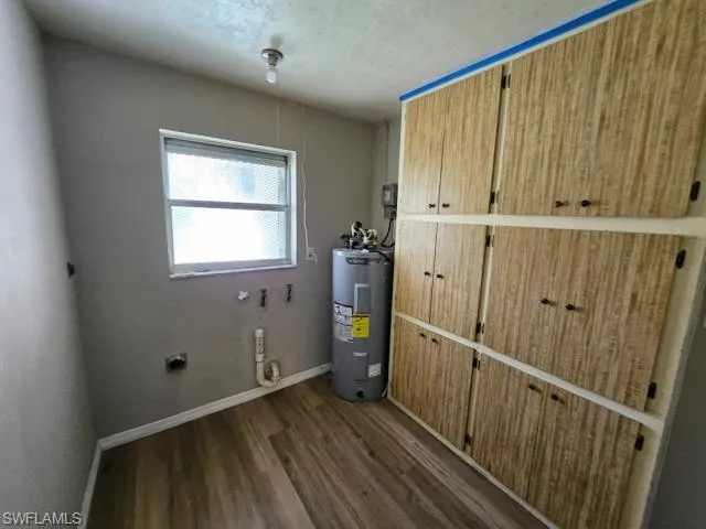 Clothes washing area with hookup for an electric dryer, water heater, and hardwood / wood-style flooring