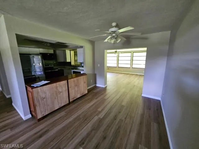 Kitchen featuring range, ceiling fan, and dark wood-type flooring