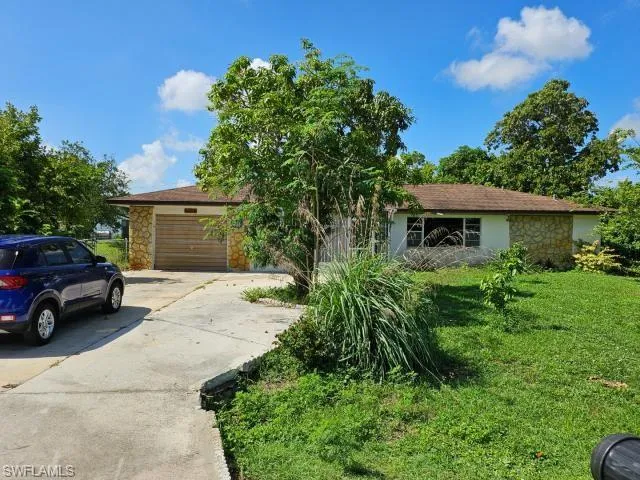 View of front facade with a garage and a front lawn