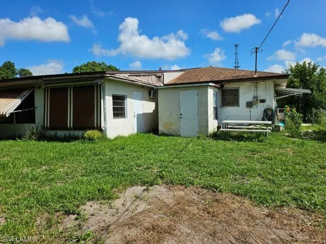 Back of property with a lawn
