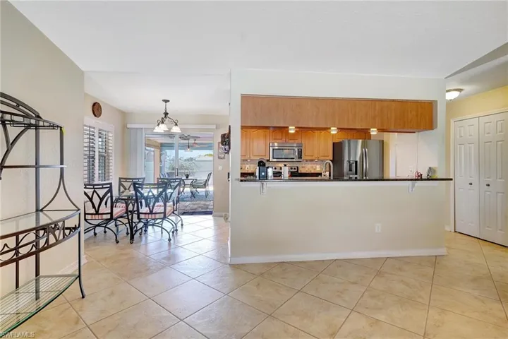 Kitchen featuring appliances with stainless steel finishes, hanging light fixtures, and light tile patterned flooring