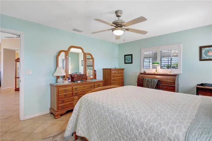 Bedroom with ceiling fan and light tile patterned flooring