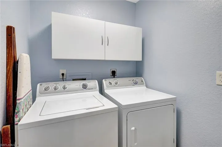 Laundry area featuring washer and dryer and cabinets