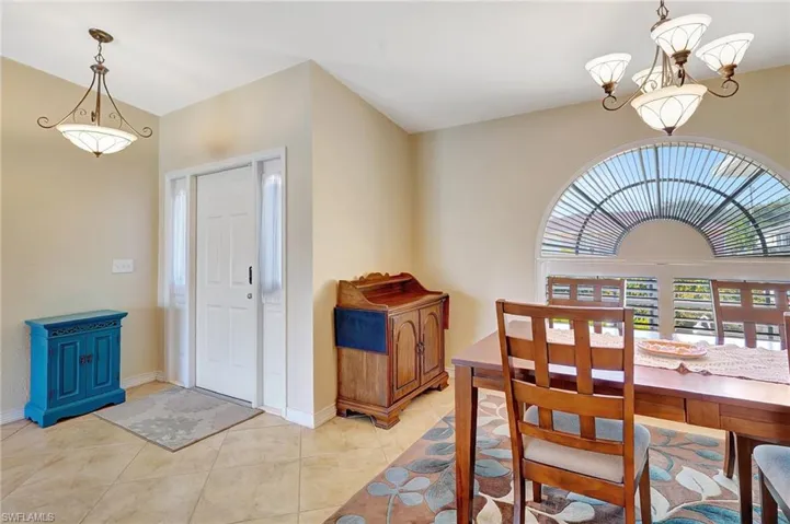 Tiled dining space featuring a notable chandelier