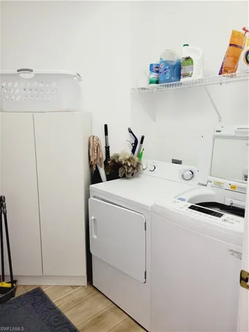 Laundry room featuring light hardwood / wood-style floors and washing machine and clothes dryer