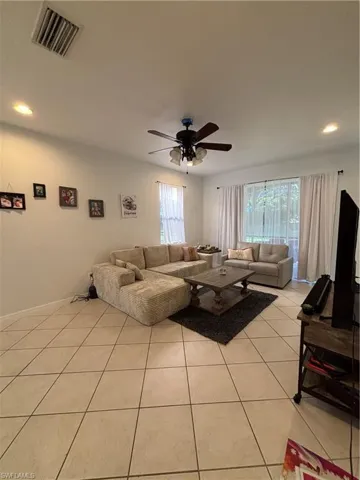 Living area featuring recessed lighting, light tile patterned flooring, and a ceiling fan