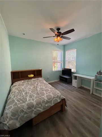 Bedroom with dark wood-style flooring and ceiling fan