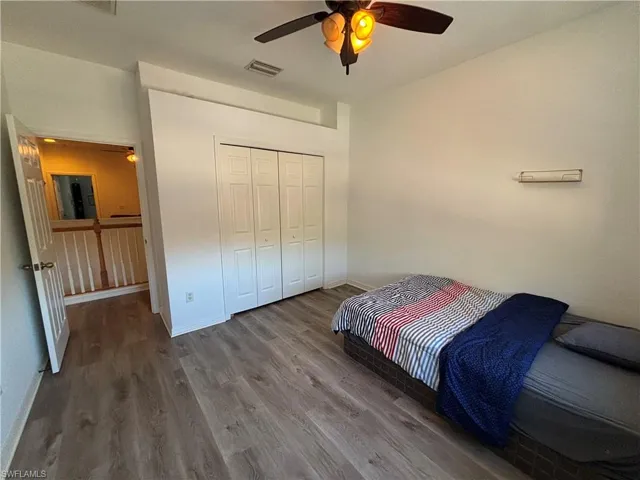 Bedroom featuring wood finished floors, a closet, and ceiling fan