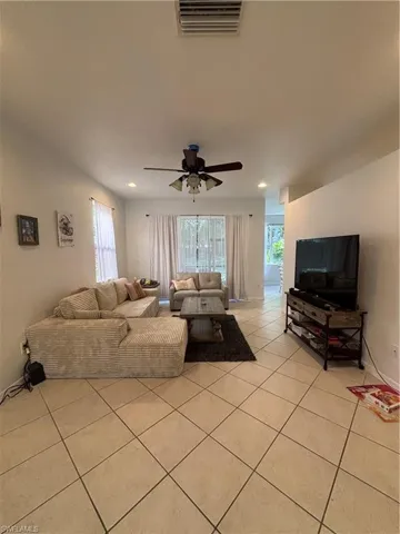 Living area with light tile patterned floors and ceiling fan