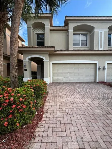 Mediterranean / spanish house with stucco siding, decorative driveway, and a garage