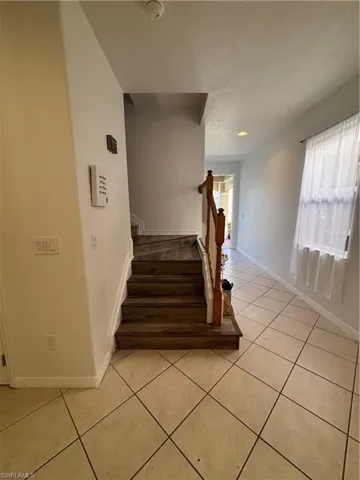 Staircase with tile patterned flooring and a textured ceiling