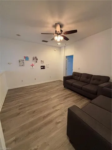 Living area featuring wood finished floors and ceiling fan