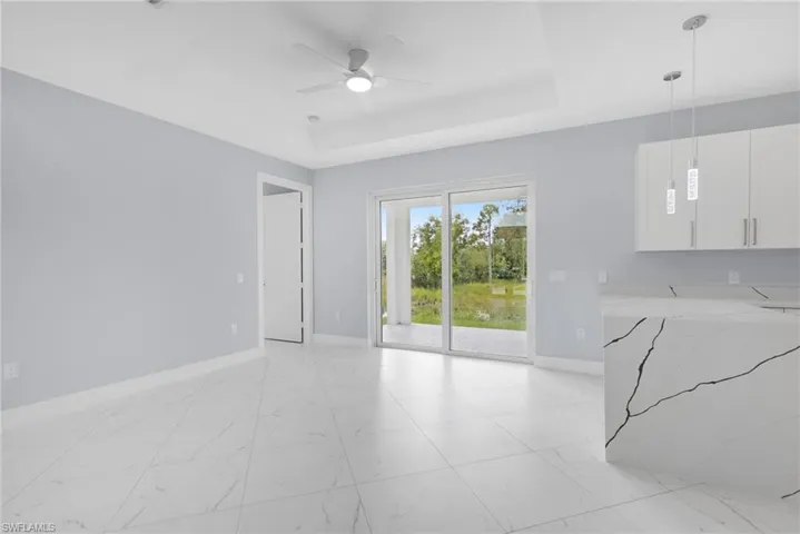 Living room with ceiling fan and a raised ceiling