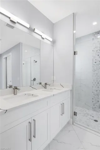 Bathroom featuring vanity and a shower with shower door