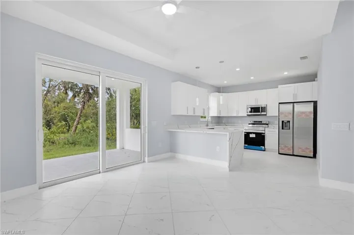 Kitchen featuring pendant lighting, white cabinetry, kitchen peninsula, appliances with stainless steel finishes, and ceiling fan