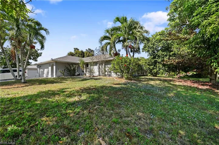 View of front of house featuring a garage, a front yard, and stucco siding