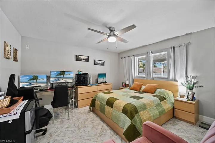 Bedroom featuring a desk, ceiling fan, and a textured ceiling