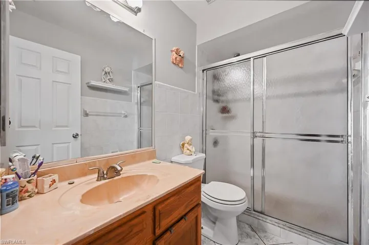 Full bathroom with vanity, tile walls, and a stall shower