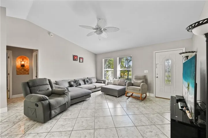 Living room with lofted ceiling and ceiling fan
