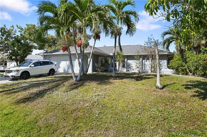 Ranch-style home featuring a garage and a front yard