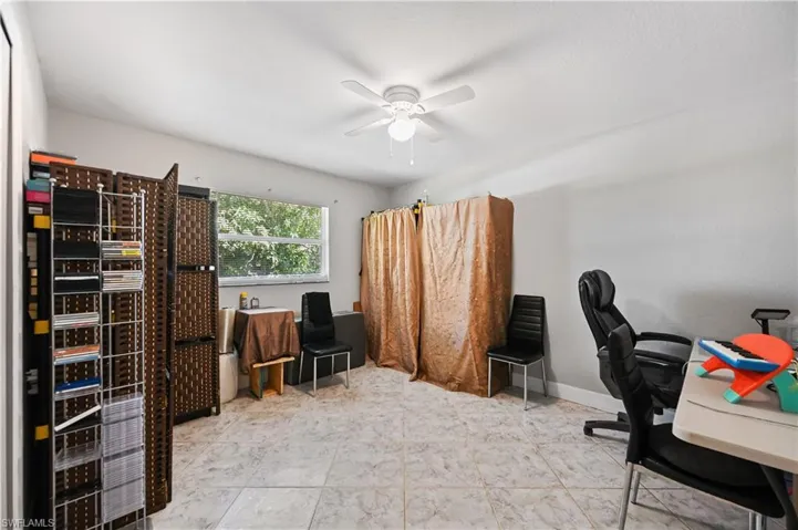 Home office with a ceiling fan and baseboards