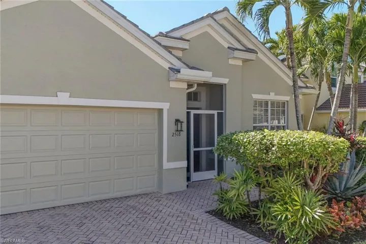 View of front facade with stucco siding and decorative driveway