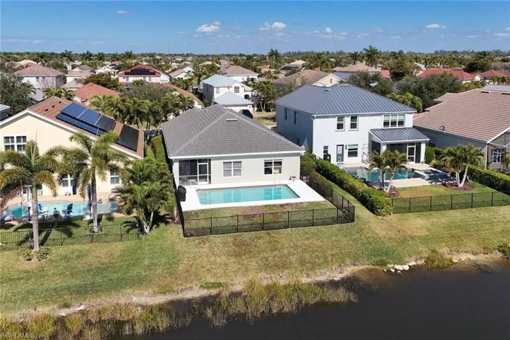 Aerial perspective of property area featuring a pool and a nearby body of water