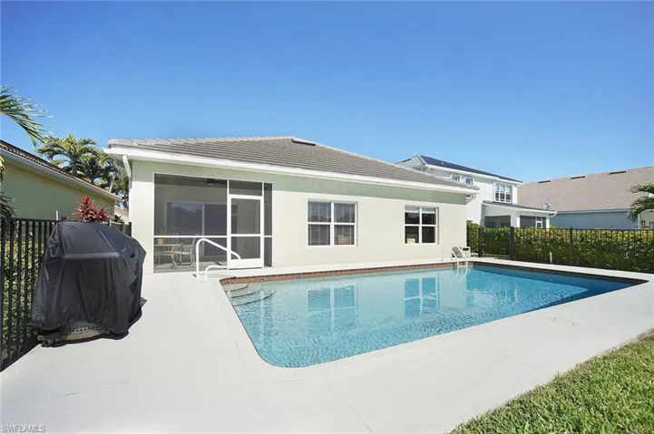 View of swimming pool featuring area for grilling, patio surround, and a sunroom