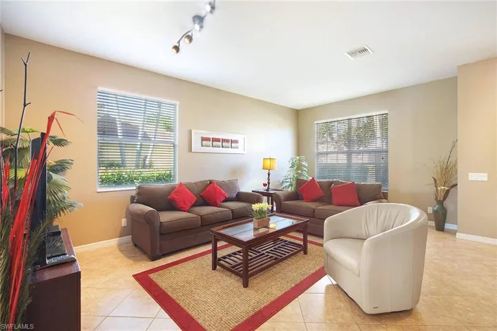 Living area featuring light tile patterned floors, rail lighting, and healthy amount of natural light