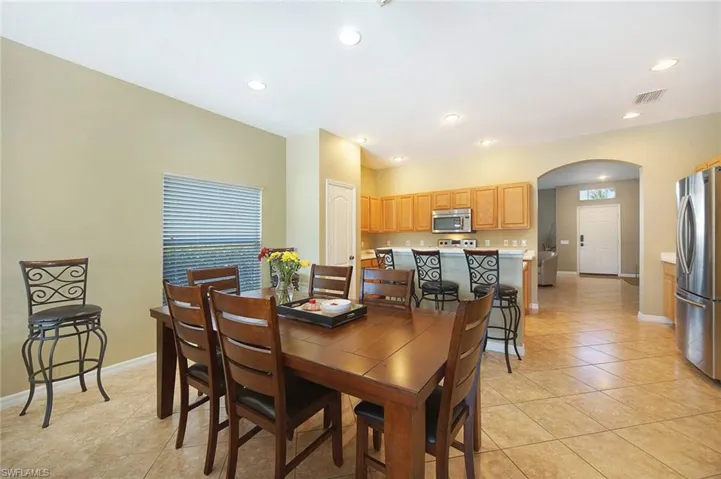 Dining room featuring arched walkways, light tile patterned flooring, and recessed lighting