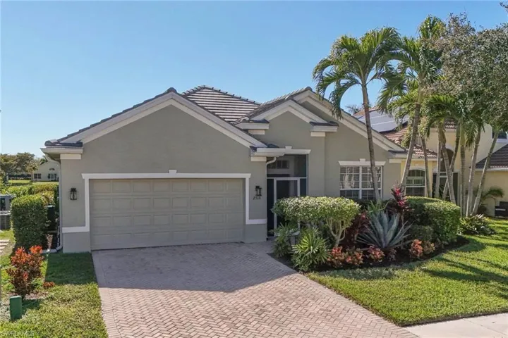 Single story home with stucco siding, decorative driveway, a garage, a front yard, and a tile roof