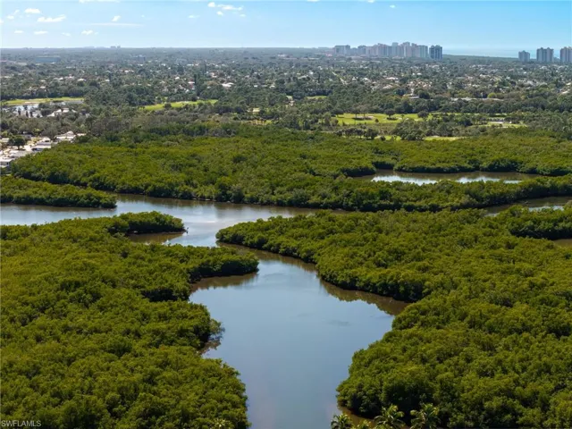 Bird's eye view of a nearby body of water and a heavily wooded area