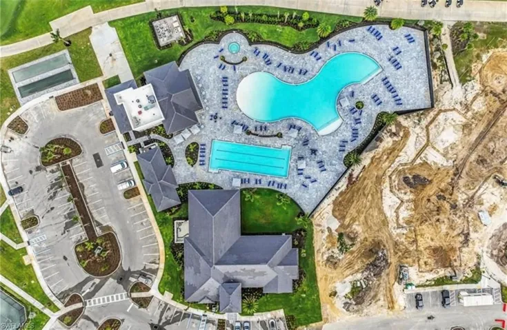 Expansive aquatic amenity featuring a large freeform pool, a rectangular lap pool, and a circular spa