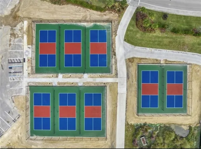 Multiple recreational courts featuring vibrant blue and red playing surfaces, surrounded by green perimeters