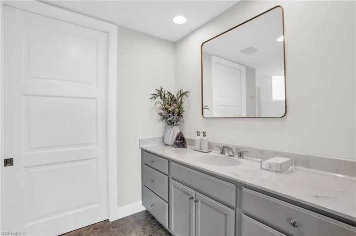 Bedroom with light carpet, connected bathroom, and ceiling fan