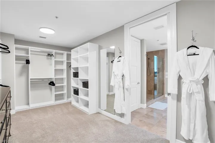 Bathroom with tile patterned flooring, walk in shower, and dual bowl vanity